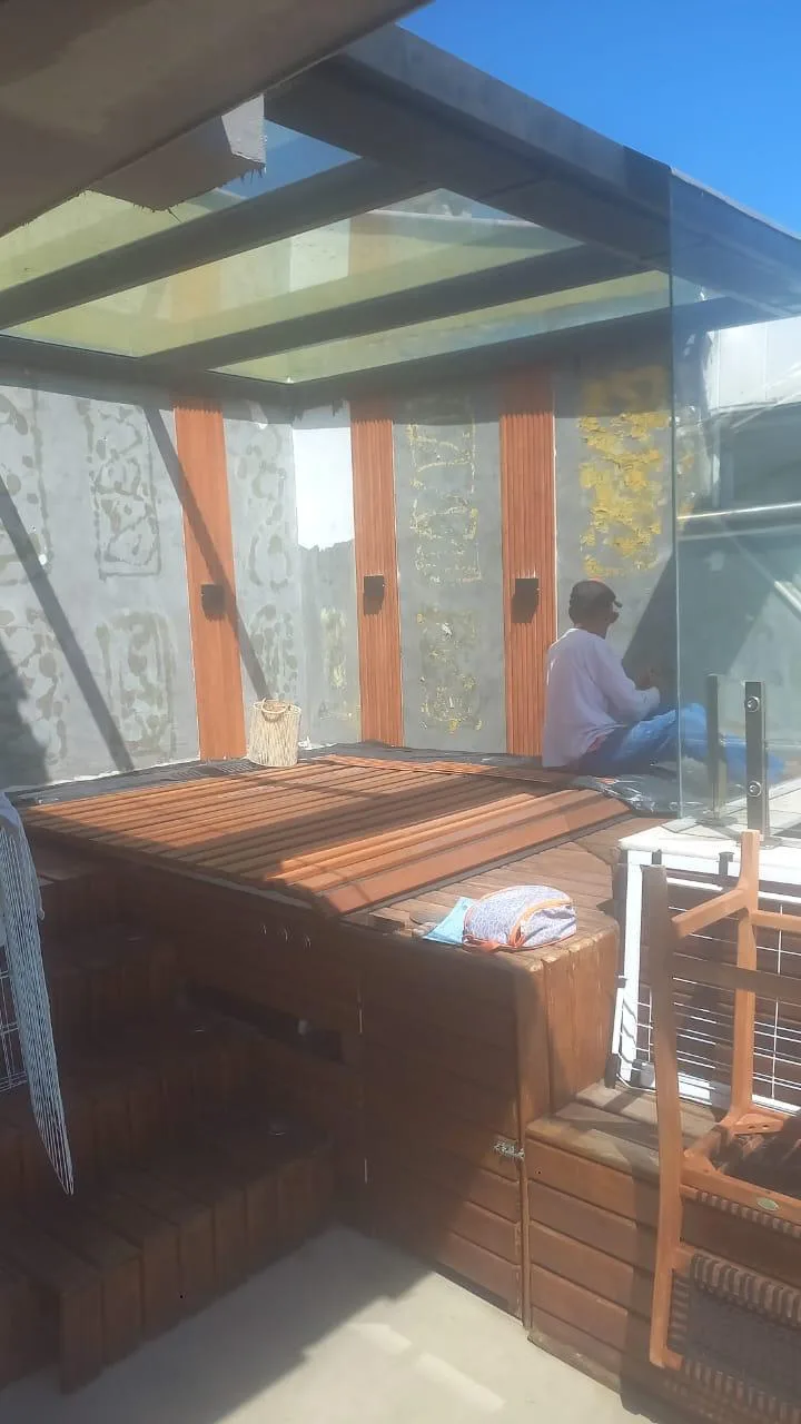 Área com deck de madeira e cobertura de vidro